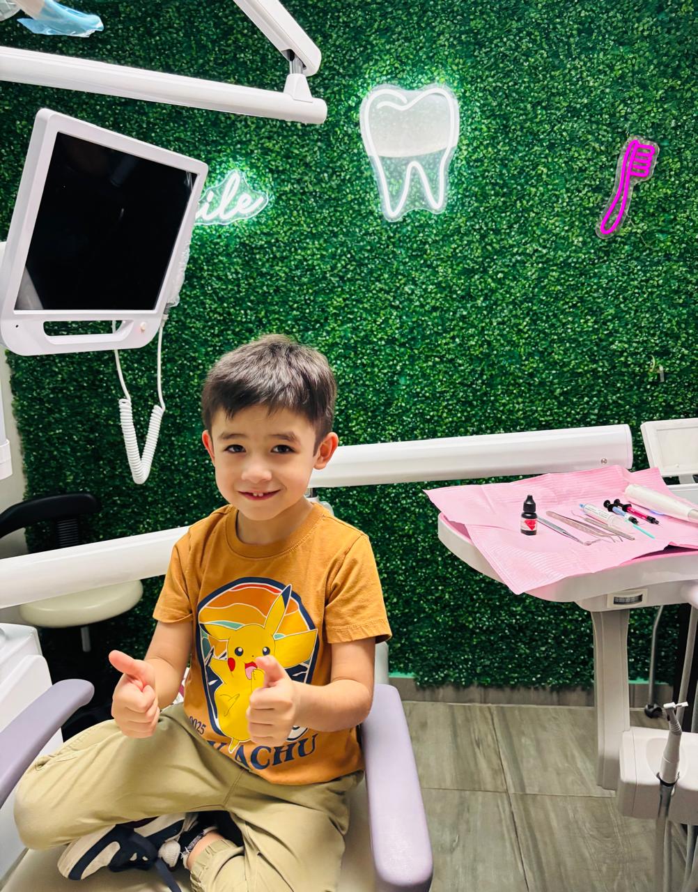 Odontopediatría en Monterrey: niño contento en sillón dental con peluche Pikachu y pulgar arriba