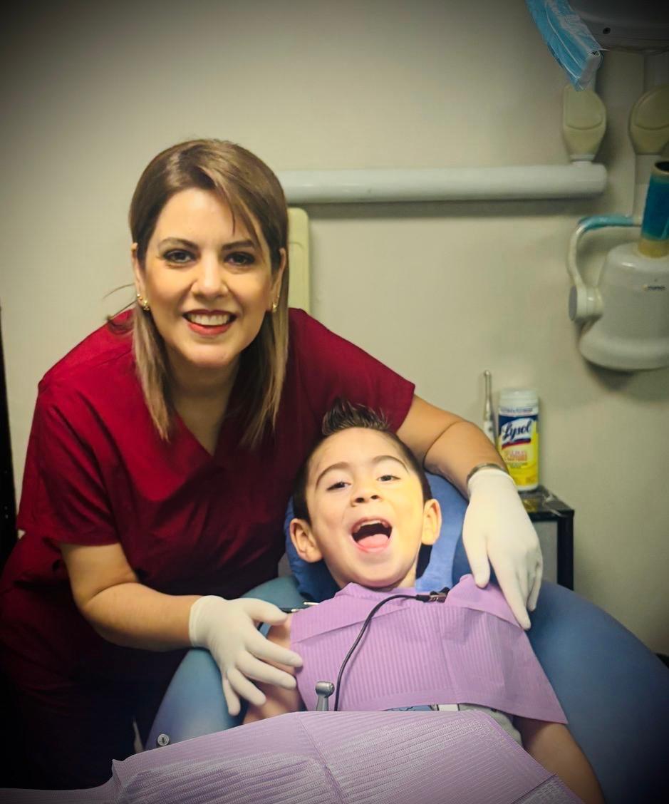 Dentista con paciente infantil sonriendo durante consulta odontológica en Monterrey