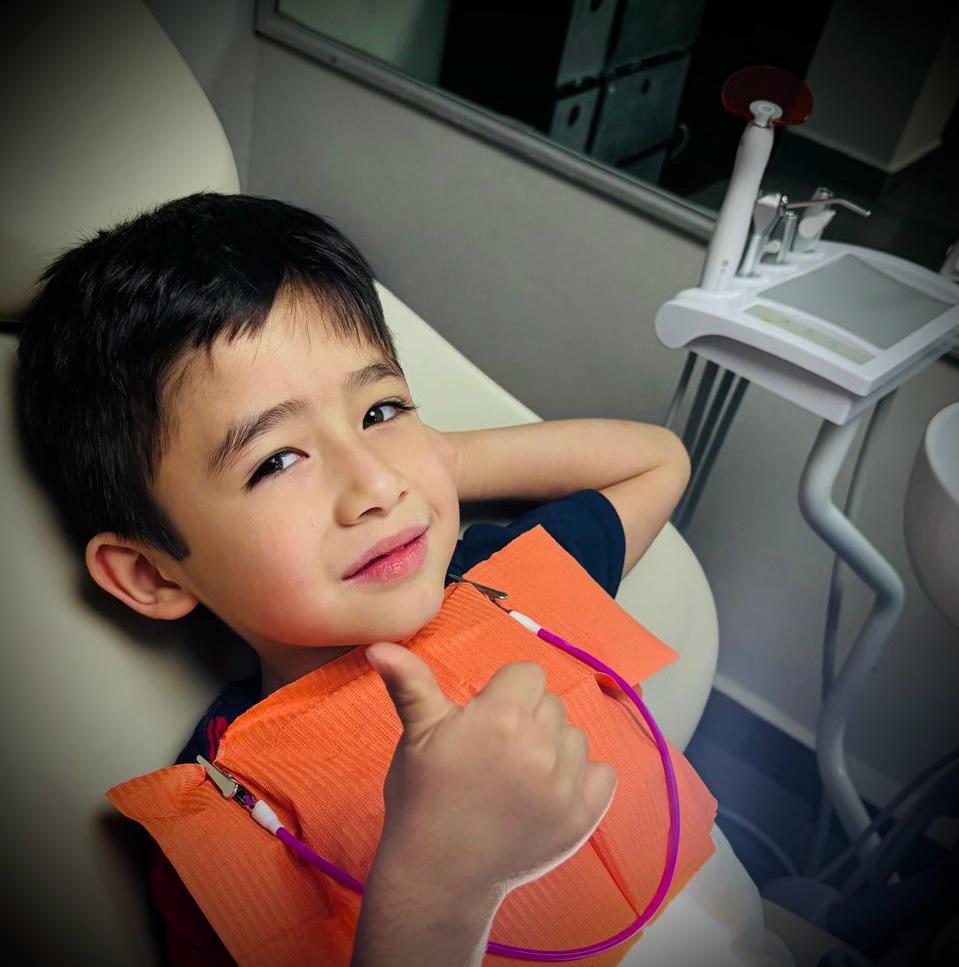 Niño paciente dando pulgar arriba después de su consulta dental en Especialidades Dentales