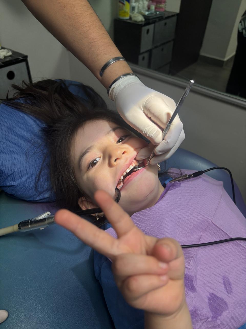 Paciente infantil haciendo signo de paz durante tratamiento de ortodoncia con brackets en Monterrey